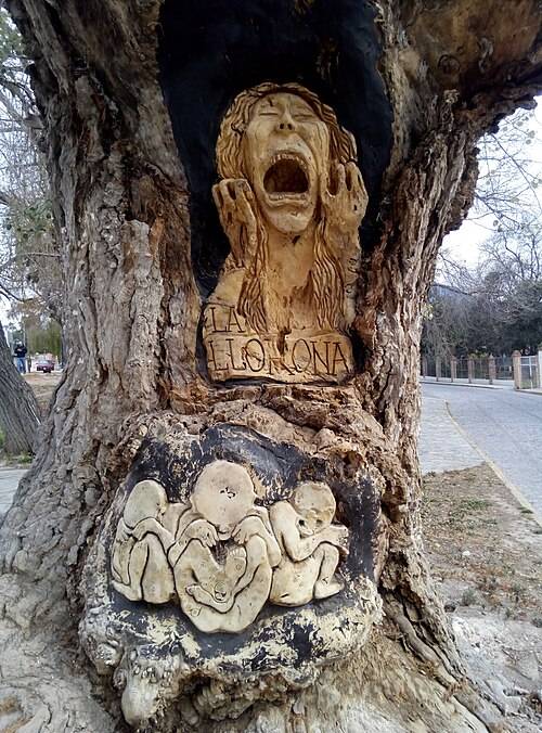 Carved tree with La Llorona and children in Arteaga, Coahuila