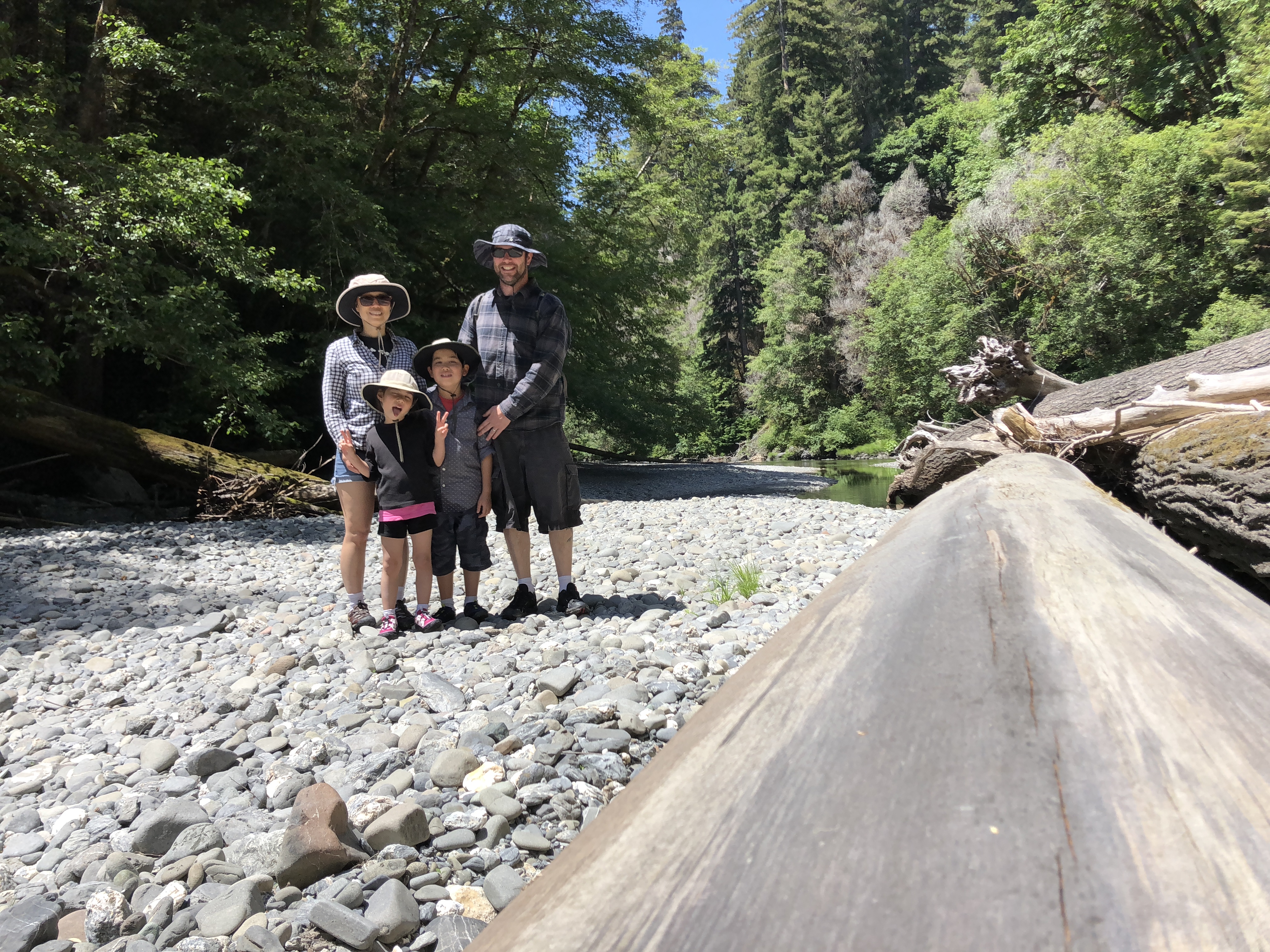 My Family posing in a dry part of Redwood Creek, next to a large driftwood tree.