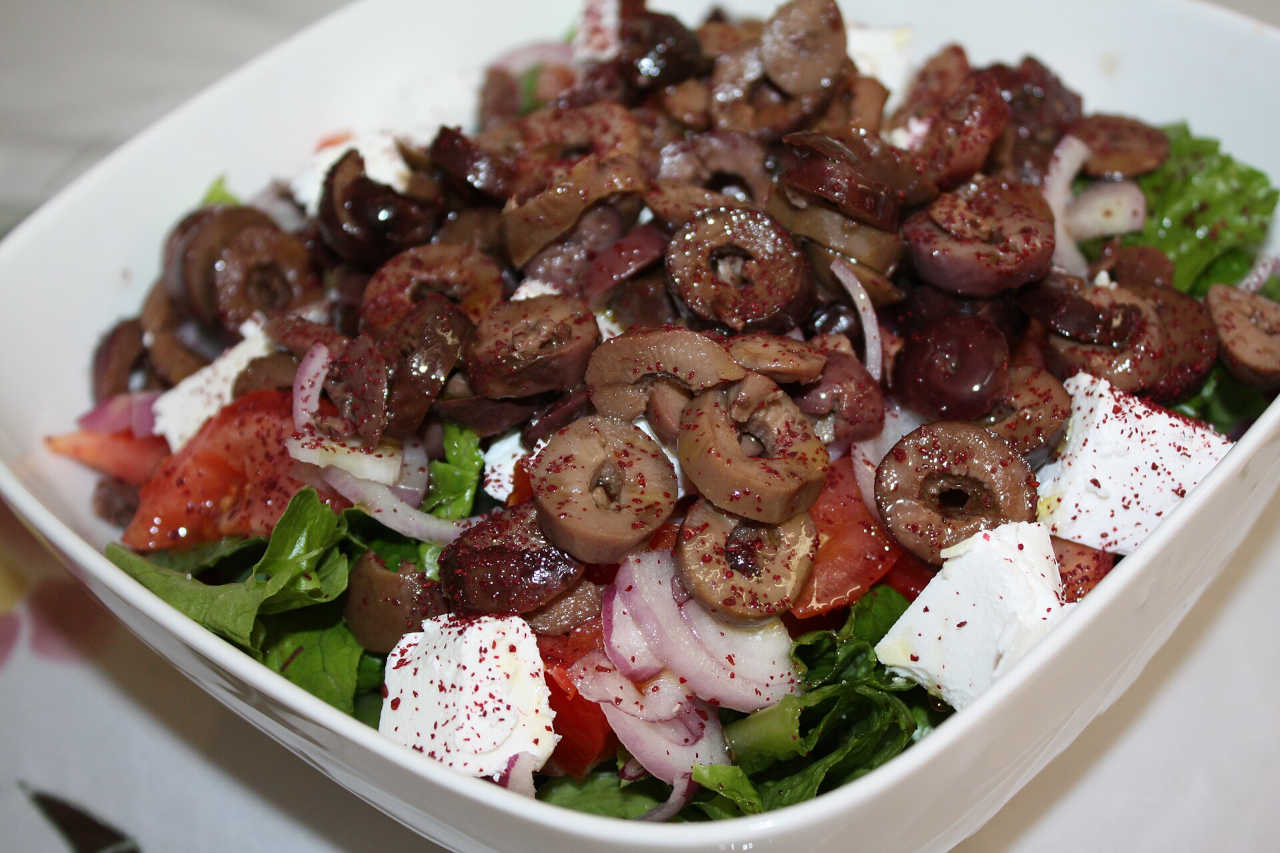 Picture of a greek salad in a white bowl.