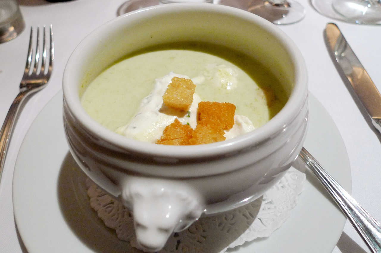 Picture of bowl of potato leak soup with croutons on top.