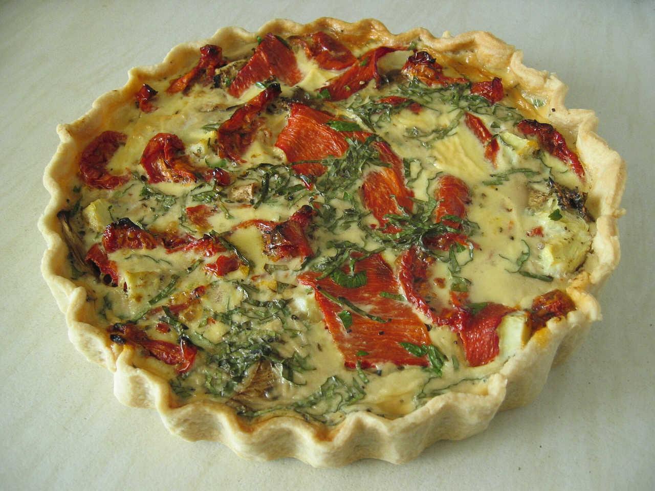 Picture of a quiche filled with salmon a basil.